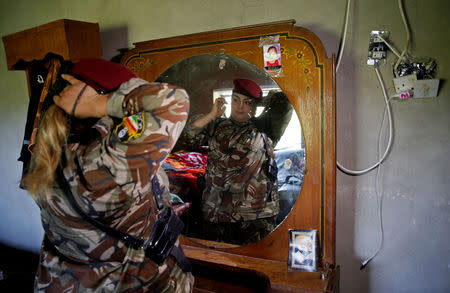 Iraqi Kurdish female fighter Haseba Nauzad, 24, looks at a mirror as she adjusts her clothes in a bedroom at a site near the frontline of the fight against Islamic State militants in Nawaran near Mosul, Iraq April 20, 2016. REUTERS/Ahmed Jadallah