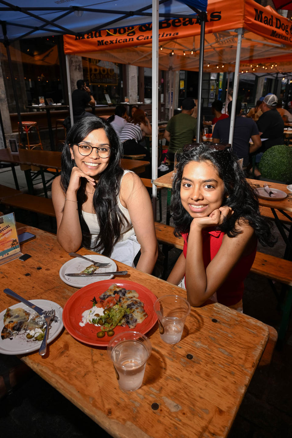 Santana Battula and Rimsha Minhaz eating lunch on Stone Street in the Financial District of New York on June 24, 2024. (Domenick Fini for NBC News)