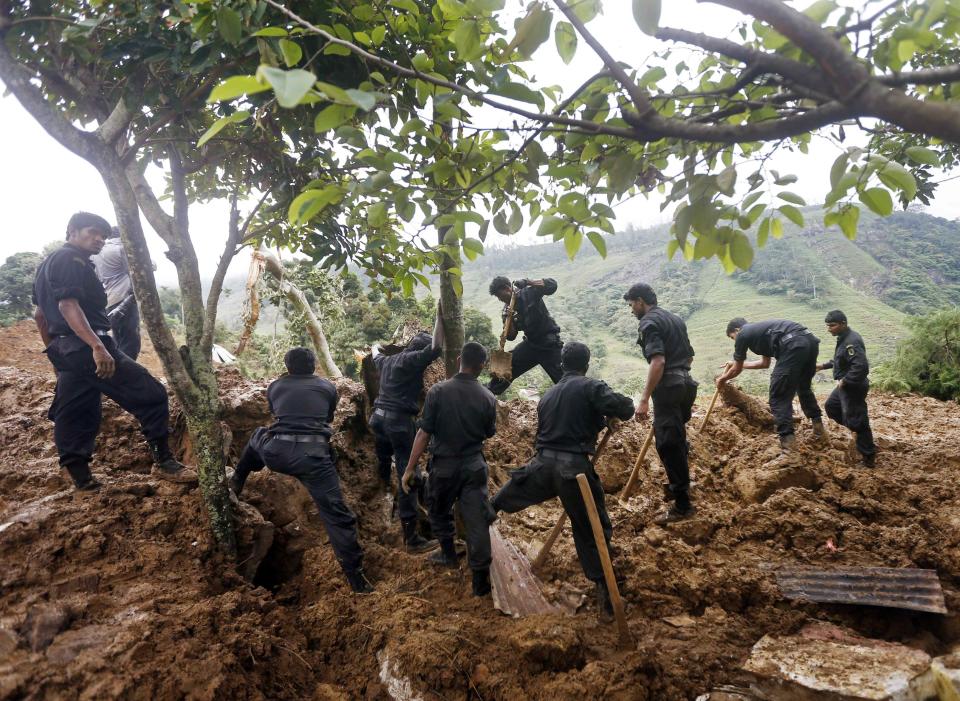 Members of a rescue team conduct a search at the site of a landslide at the Koslanda tea plantation near Haldummulla