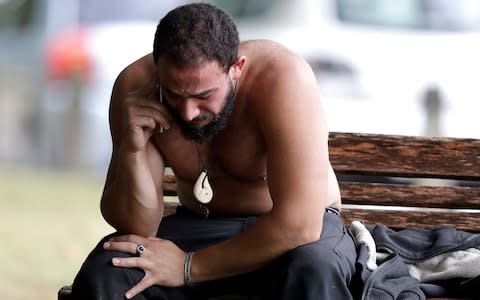 A man reacts as he speaks on a mobile phone near a mosque in central Christchurch, New Zealand