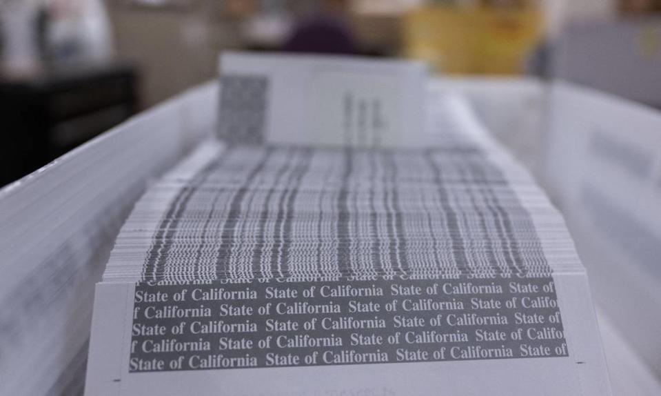 A stack of California state worker paychecks wait to be sealed at the state controller’s printing facility on Aug. 24.
