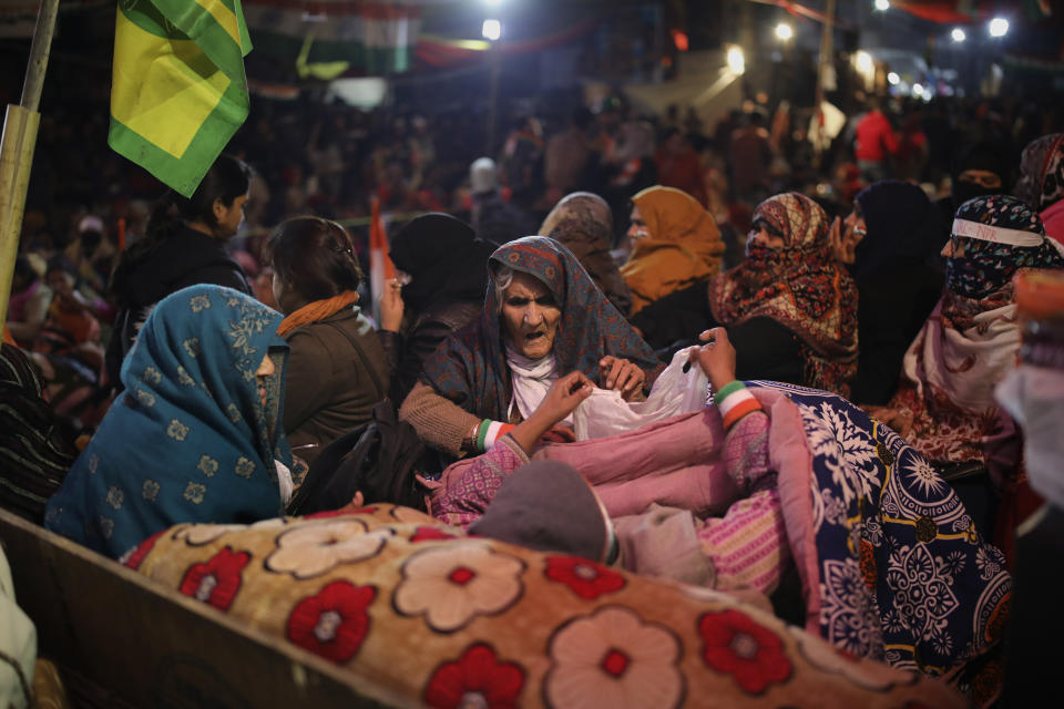 In this Wednesday, Jan. 22, 2020 photo, 90-year-old Asma Khatoon, center, tends to a sick fellow protester inside a tent at the protest site in New Delhi's Shaheen Bagh area, India. In this neighborhood, beside open sewers and dangerously dangling electricity wires, a group of Muslim women in colorful headscarves sit in the middle of a street in resistance to a new citizenship law that has unleashed protests across the country. The neighborhood rings with chants of “Inquilab Zindabad", a phrase which translates to “Long live the revolution!” As the night draws closer, women as old as 90 huddle together under warm blankets, falling asleep on cheap mattresses. (AP Photo/Altaf Qadri)