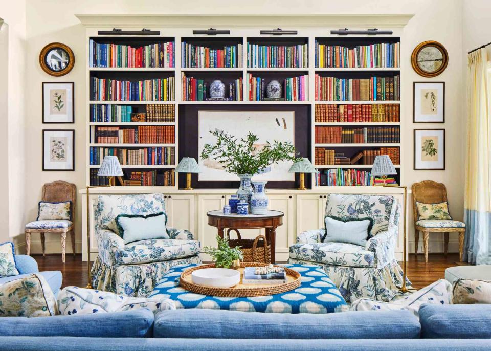 Laurey W. Glenn; Styling by Lindsey Ellis Beatty The two-story, open-plan living room needed grounding, so designer Caroline Gidiere expanded the existing built-ins to anchor the space. Black paint on the interior of the shelves originally hid a TV, but the family moved it to the den and hung artwork by Jennifer Daily.