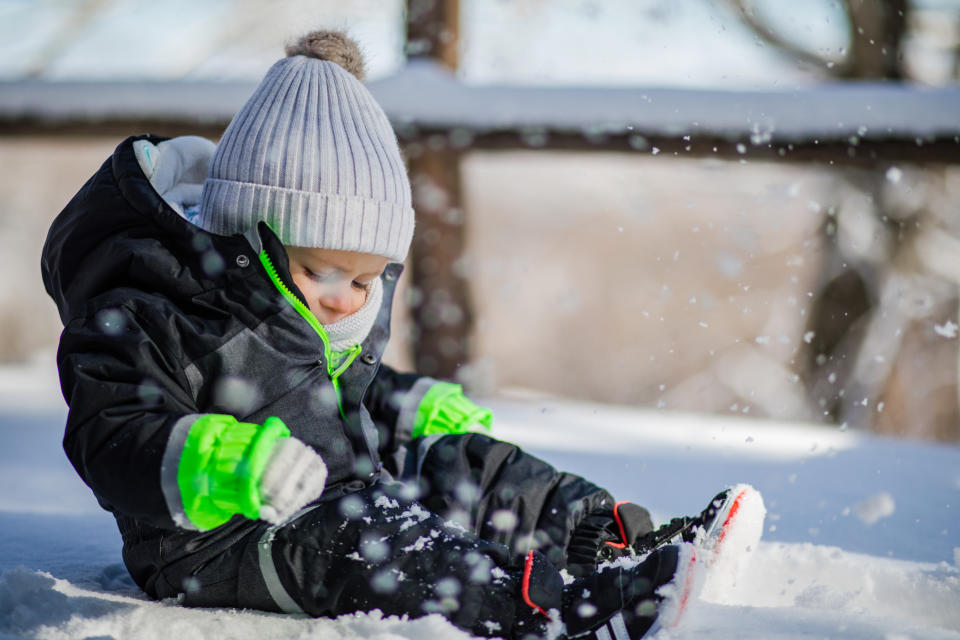 Happy baby boy playing in the snow