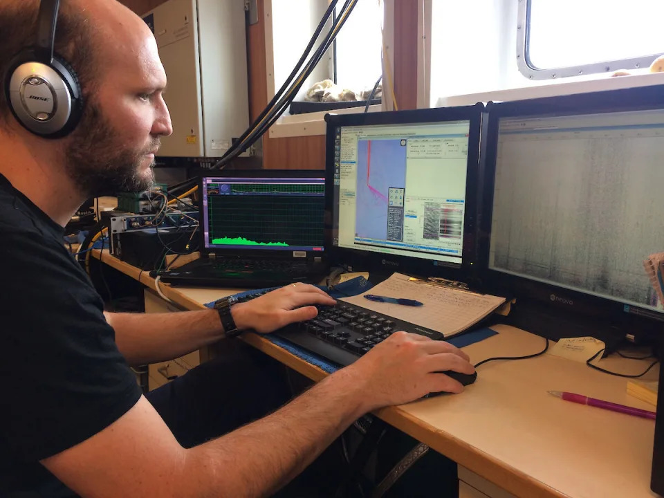 Lead author Brian Miller listens for the sound of an Antarctic blue whale. Elanor Miller / Australian Antarctic Division