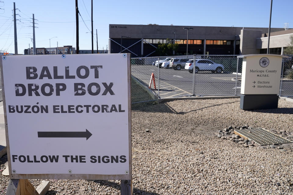 Signs direct voters to drop off their ballots at a secure ballot drop box at the Maricopa County Tabulation and Election Center in Phoenix, Monday, Oct. 31, 2022. (AP Photo/Ross D. Franklin)