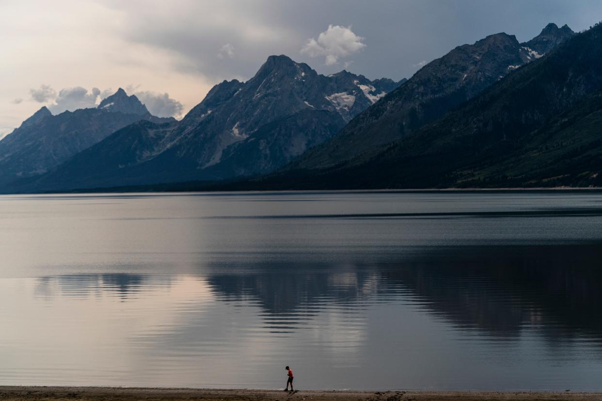 In this photo from August 2022, a teen boy walks along Jackson Lake in Grand Teton National Park.