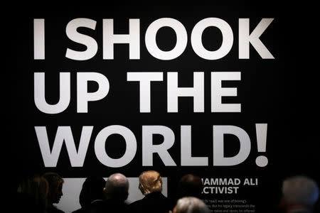 U.S. President Donald Trump (C) looks at exhibits as he visits the National Museum of African American History and Culture on the National Mall in Washington, U.S., February 21, 2017. The quote from boxer and activist Muhammad Ali, "I shook up the world!" is painted at the end of the hall. REUTERS/Jonathan Ernst