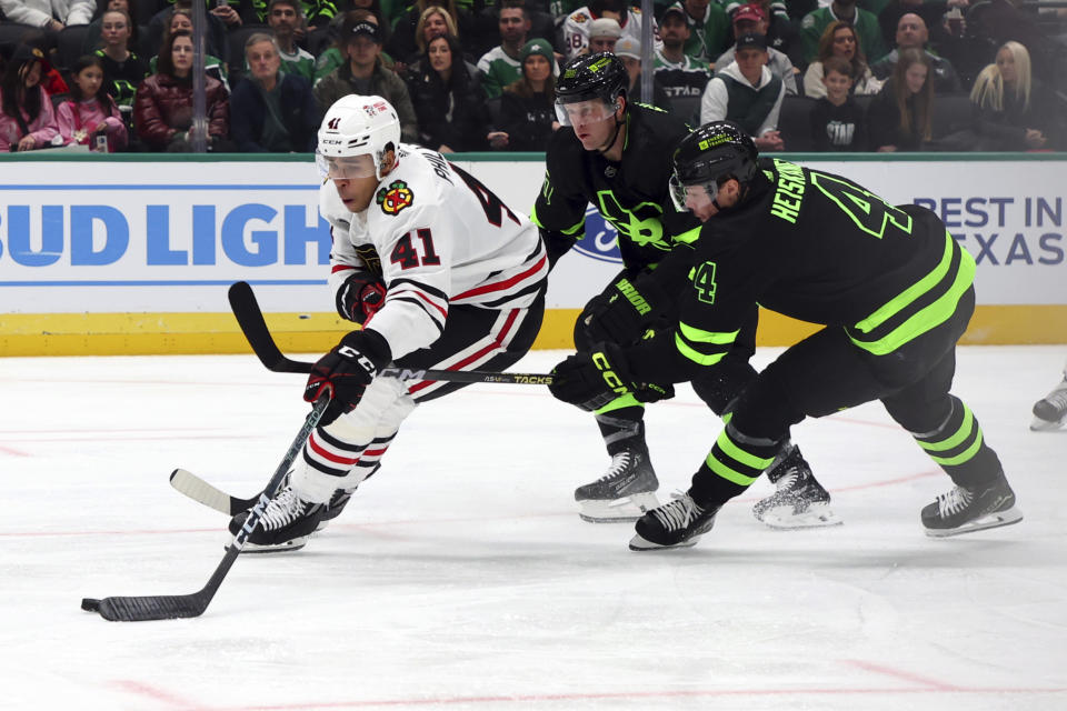 Chicago Blackhawks defenseman Isaak Phillips (41), Dallas Stars defenseman Ryan Suter and defenseman Miro Heiskanen chase the puck in the second period of an NHL hockey game, Sunday, Dec. 31, 2023, in Dallas. (AP Photo/Richard W. Rodriguez)