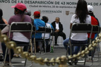 Mexico's President Andres Manuel Lopez Obrador, center, and family members of 43 missing students from the Rural Normal School of Ayotzinapa, listen to an update to the ongoing investigations on the sixth anniversary of the students' disappearance, at the National Palace in Mexico City, Saturday, Sept. 26, 2020. (AP Photo/Rebecca Blackwell)