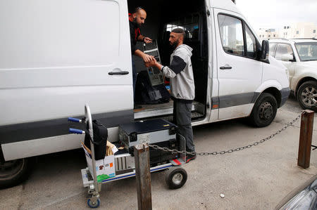 An undercover Israeli security officer loads a van with documents and a computer hard-drive seized from a Palestinian map office by Israeli security officers as they carry out an Israeli police order to close the office, in the Arab East Jerusalem neighbourhood of Beit Hanina March 14, 2017. REUTERS/Ammar Awad