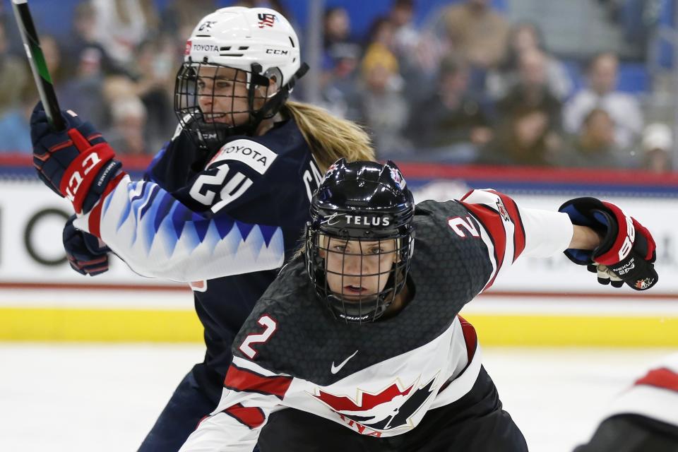 Canada's Meghan Agosta (2) defends against United States' Dani Cameranesi (24) during the first period of a rivalry series women's hockey game in Hartford, Conn., Saturday, Dec. 14, 2019. (AP Photo/Michael Dwyer)