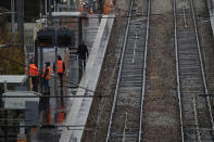 Informations workers stand on a platform at an empty Paris suburb train station Thursday, Dec. 12, 2019 in Sevres, west of Paris. Unions have flatly rejected fresh proposals by the government of pro-business President Emmanuel Macron to stagger the roll-out of a plan that would require France's youngest workers - people born after 1974 - to stay on the job until the age of 64 to get full pensions instead of age 62. (AP Photo/Christophe Ena)