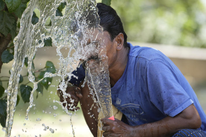 FILE - A person sprays water on his face from an irrigation pipe to beat the intense heat wave in Lucknow in the the Indian state of Uttar Pradesh, April 19, 2023. A searing heat wave in parts of southern Asia in April this year was made at least 30 times more likely by climate change, according to a rapid study by international scientists released Wednesday, May 17. (AP Photo/Rajesh Kumar Singh, File)