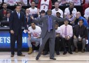 Toronto Raptors coach Dwane Casey gestures at a referee as musician Drake, lower center left, watches during the first half of Game 1 of an opening-round NBA basketball playoff series, in Toronto on Saturday, April 19, 2014. (AP Photo/The Canadian Press, Darren Calabrese)
