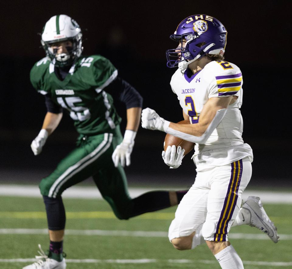 Jackson's Anthony Fuline scores a first-half touchdown as Central Catholic defender Braylwyn Tabelion closes in, Friday, Oct. 13, 2023.