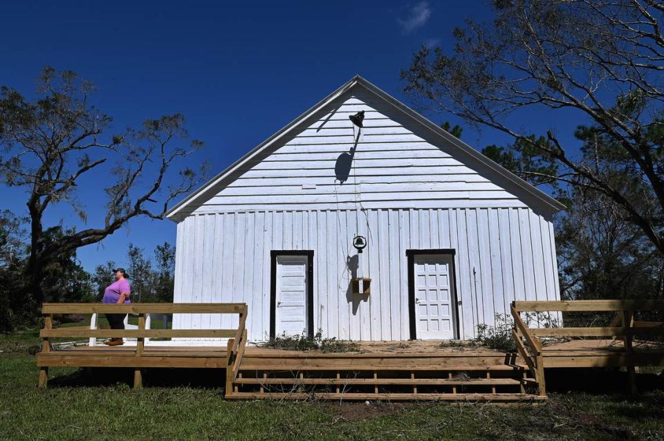 Erected in 1908, the Sandy Baptist Church in Myakka City withstood Hurricane Ian’s brutal winds, suffering some roof and window damage. Faye Mosley stands on a porch built more recently, looking out at the downed trees around the property.