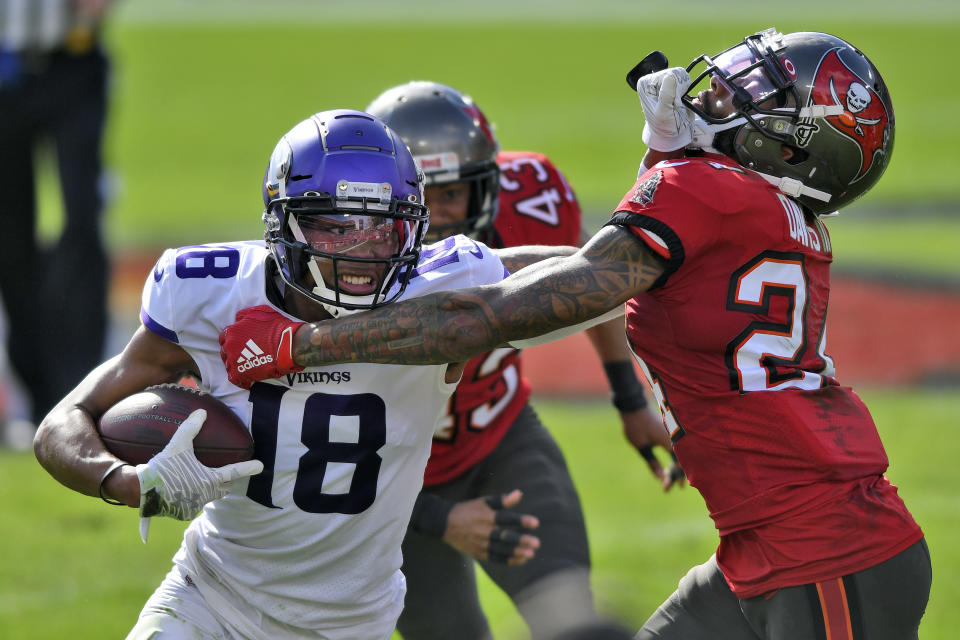 Minnesota Vikings wide receiver Justin Jefferson (18) stiff arms Tampa Bay Buccaneers cornerback Carlton Davis (24) after a catch during the first half of an NFL football game Sunday, Dec. 13, 2020, in Tampa, Fla. (AP Photo/Jason Behnken)