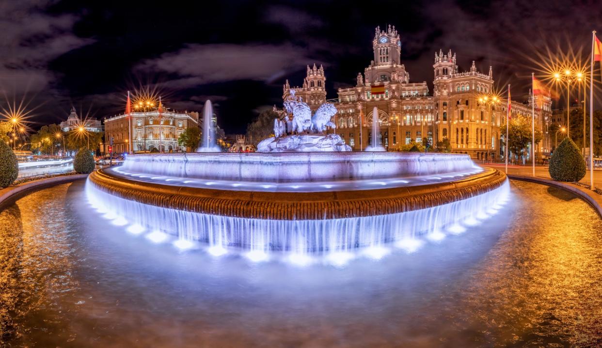 Plaza de Cibeles fountain and Palacio de Comunicaciones illuminated at night in Madrid, Spain