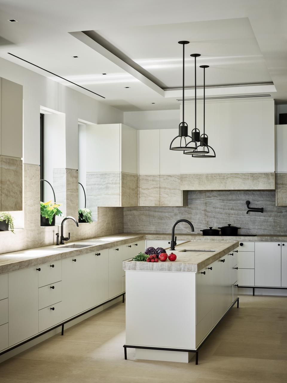 Joyner enlisted his private chef to help design his kitchen to her specifications. Weceselman drew inspiration from French designs for the overall aesthetic. The unique cabinet composition is wood with stone inserts and were custom created by Wecselman Design. The pendants over the island are by Holly Hunt.