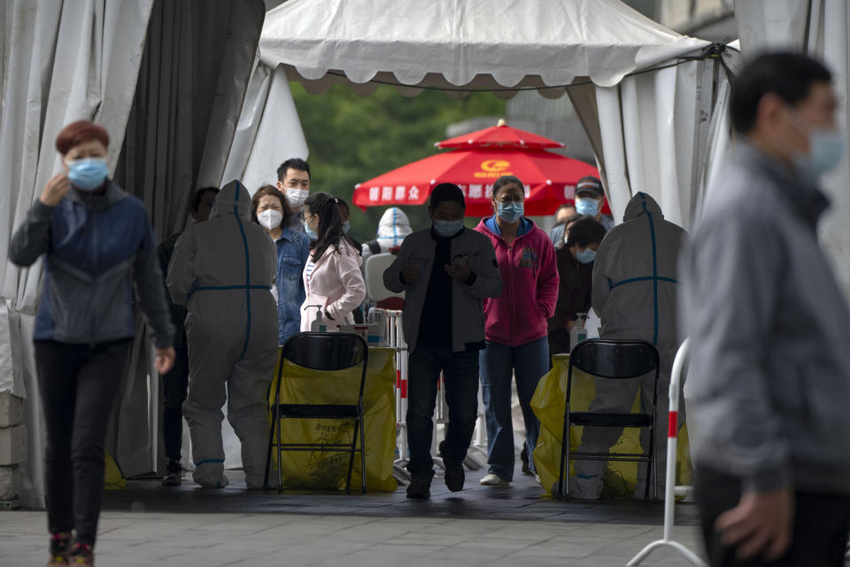 People wearing face masks stand in line for COVID-19 tests at a coronavirus testing site in Beijing, Wednesday, May 11, 2022. Shanghai reaffirmed China's strict "zero-COVID" approach to pandemic control Wednesday, a day after the head of the World Health Organization said that was not sustainable and urged China to change strategies. (AP Photo/Mark Schiefelbein)
