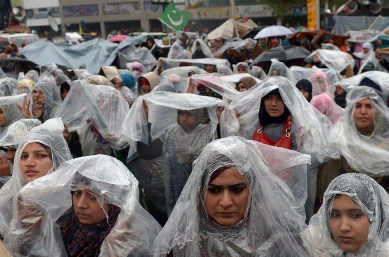 Supporters of Pakistani cleric Tahir-ul Qadri gather in the rain at a protest rally in Islamabad on January 17, 2013. Qadri called off a mass protest in Islamabad, averting a major political crisis and reaching a deal with the government that paves the way for elections within months