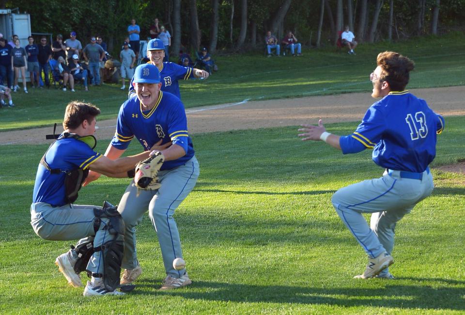 Clear Spring catcher Damien Pittsnogle tackles pitcher Dawson Kehr after the Blazers completed a 13-5 victory over Catoctin on May 17 to win the Class 1A West Region II title. Bennett Decker (13) charges off the bench to join the celebration.