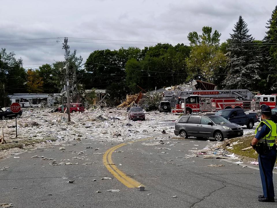 A police officer stands guard at the scene of a deadly propane explosion that leveled a new building in Farmington, Maine.