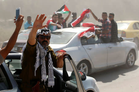 People celebrate as Palestinian Prime Minister Rami Hamdallah arrives to take control of Gaza from the Islamist Hamas group, in the northern Gaza Strip October 2, 2017. REUTERS/Mohammed Salem