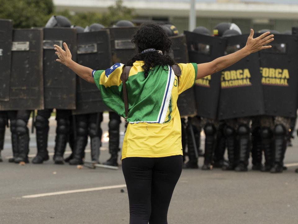 A supoprter of former President Jair Bolsonaro confront security forces