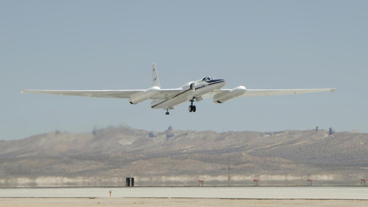  An aircraft with a large wingspan takes off in the desert. 