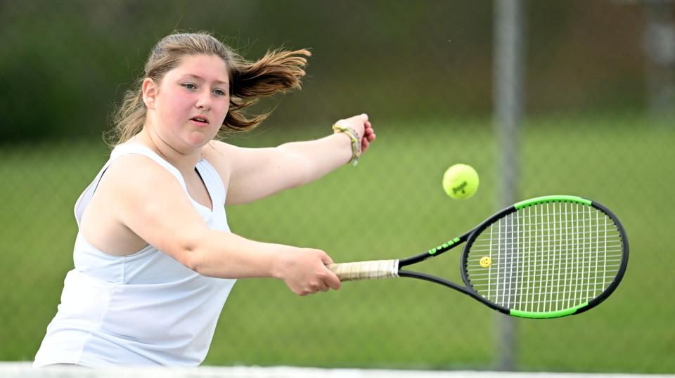 Falmouth number one doubles player Alexis Christian backhands at the net against Barnstable.