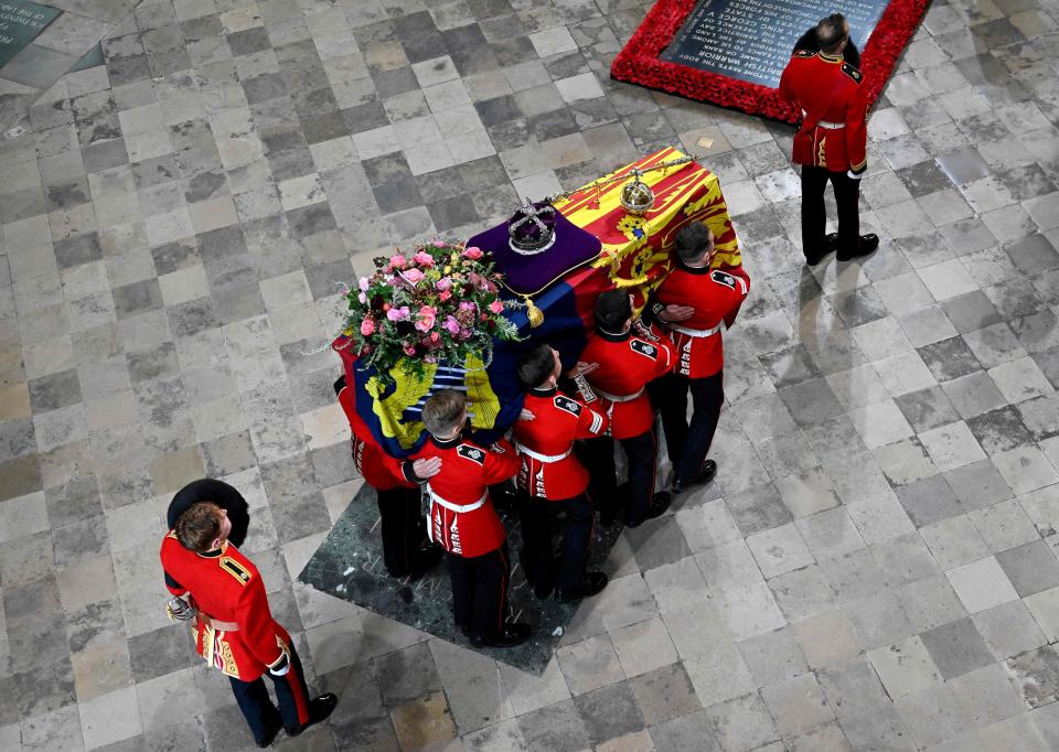 A Bearer Party of The Queen's Company, 1st Battalion Grenadier Guards carries the coffin of Queen Elizabeth II, draped in the Royal Standard, into Westminster Abbey in London on Sept. 19, 2022, ahead of the state funeral.