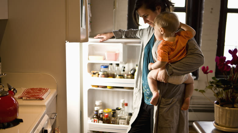 mom and baby opening fridge