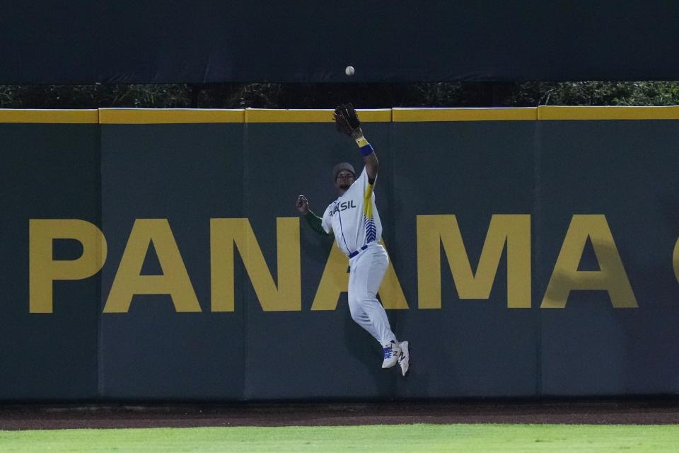 El jardinero central de Brasil, Luciano Fernando, atrapa un elevado de Rodrigo Orozco, de Panamá, durante la segunda entrada de un juego clasificatorio para el Clásico Mundial de Béisbol en el Estadio Nacional Rod Carew en Ciudad de Panamá, el martes 4 de octubre de 2022. (Foto AP/Arnulfo Franco )