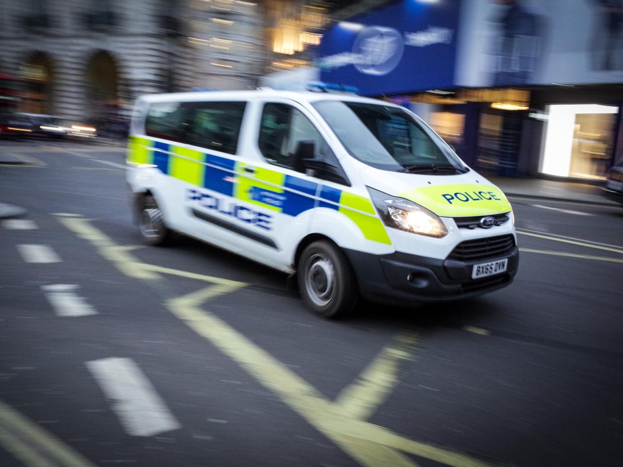 A Metropolitan Police van drives through Piccadilly Circus at dusk