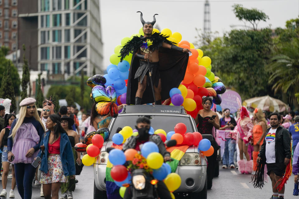 Una persona avanza encima de un carro alegórico durante un desfile del Orgullo Gay que marca la culminación del mes del Orgullo LGBTQ+, el sábado 29 de junio de 2024, en Ciudad de Guatemala. (AP Foto/Moisés Castillo)