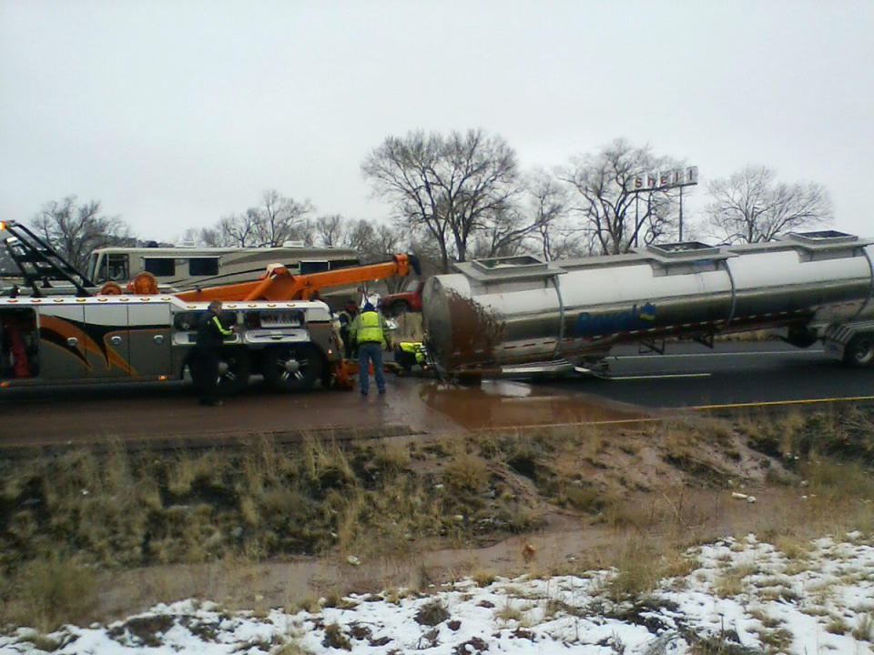 This Monday, Jan. 14, 2019 photo provided by the Arizona Department of Public Safety shows the scene of a crash about 11 miles east of Flagstaff, Ariz. A tank trucker’s trailer detached from the truck and rolled on its side on slick pavement, spilling a river of liquid chocolate onto westbound lanes of Interstate 40. Department of Public Safety spokesman Bart Graves said the wreck required cleanup crews to pour most of the 40,000 gallons (151,412 liters) of chocolate into the highway median to lighten the damaged tanker so it could be towed away. The DPS said there were no injuries and the driver was not cited. (Arizona DPS via AP)