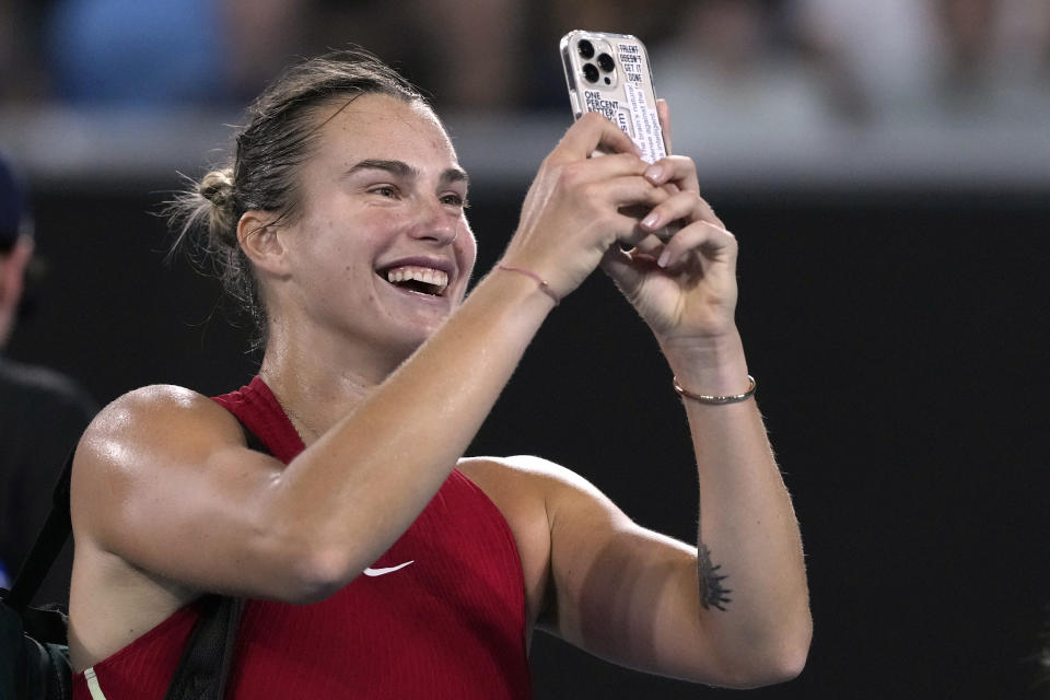 Aryna Sabalenka of Belarus takes a selfie on a mobile phone after defeating Amanda Anisimova of the U.S. in their fourth round match at the Australian Open tennis championships at Melbourne Park, Melbourne, Australia, Sunday, Jan. 21, 2024. (AP Photo/Andy Wong)