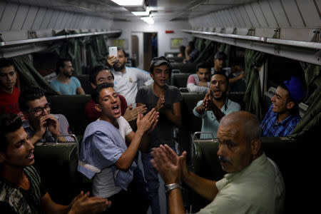 People sing in a train as they travel through the outskirts of Damascus towards recently opened international fair in Damascus, Syria, September 12, 2018. REUTERS/Marko Djurica