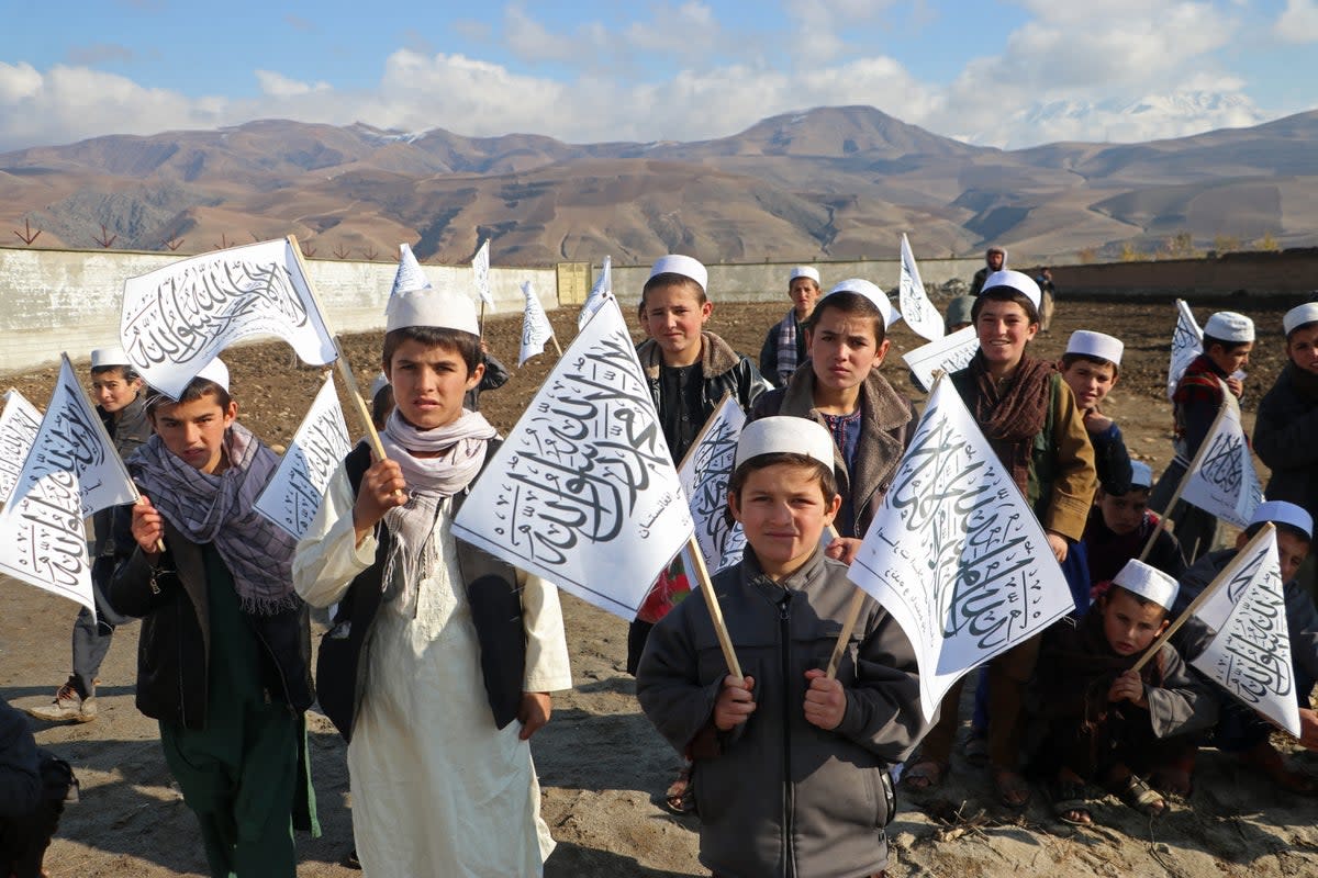 Afghan children from a Madrassa or an Islamic school hold Taliban’s flag in Fayzabad district of Badakhshan (AFP via Getty Images)