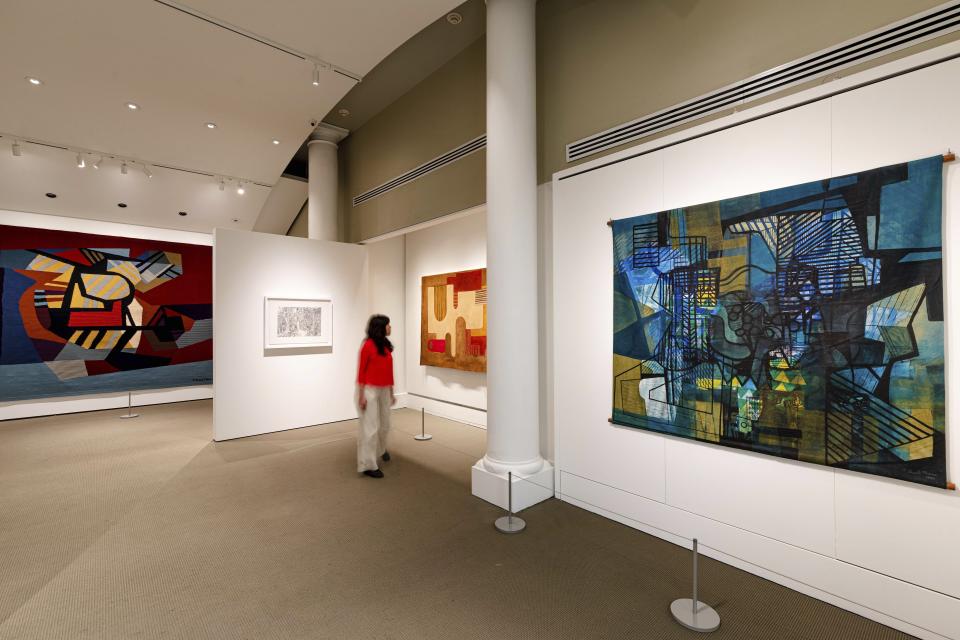 This undated photo provided by The New York Botanical Garden shows a visitor in NYBG's Art Gallery looking at the artwork of Roberto Burle Marx in part of the exhibit "Brazilian Modern: The Living Art of Roberto Burle Marx" at NYBG in New York. In what NYBG has dubbed its largest botanical exhibition ever, the exhibit celebrates the Brazilian modern artist, landscape architect and conservationist. (The New York Botanical Garden via AP)