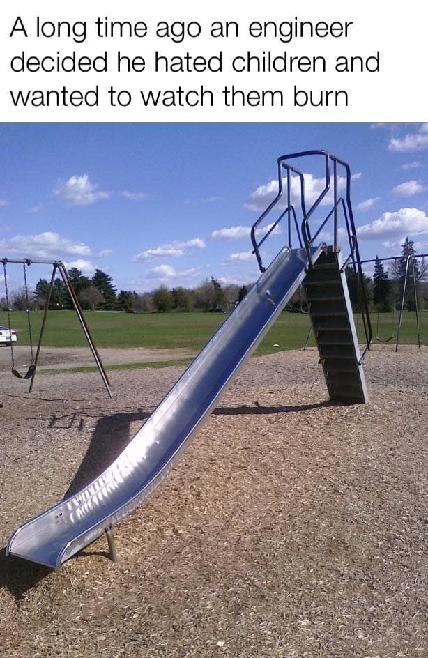 An empty playground with a metal slide that is extremely steep, captioned "A long time ago an engineer decided he hated children and wanted to watch them burn."