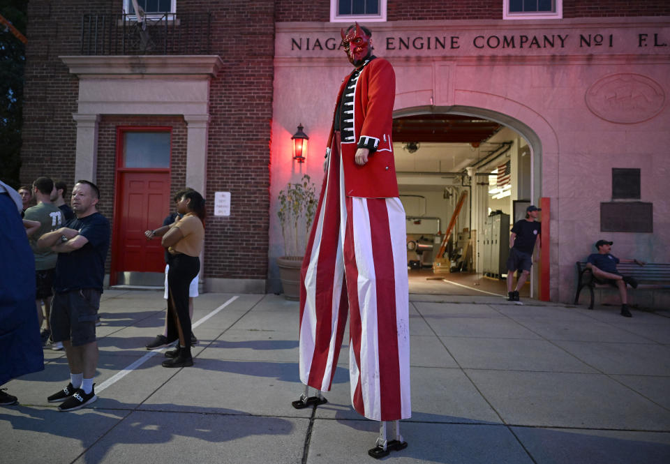 A man on stilts dressed as the Devil stands outside the New London Fire Department during the annual Burning of Benedict Arnold Festival, Saturday, Sept. 9, 2023, in New London, Conn. The burning of Arnold marks the anniversary of the day in September 1781 that the Connecticut native led British troops into the city and burned most of it to the ground. (AP Photo/Jessica Hill)