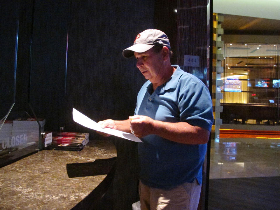 In this Sept. 4, 2019 photo, Andy Lanni of Oceanview, N.J. checks the odds at the sports book in the Borgata casino in Atlantic City, N.J. As the second NFL season begins following a U.S. Supreme Court decision clearing the way for legal sports betting, the industry is growing larger and ever-more mobile in the U.S. (AP Photo/Wayne Parry)