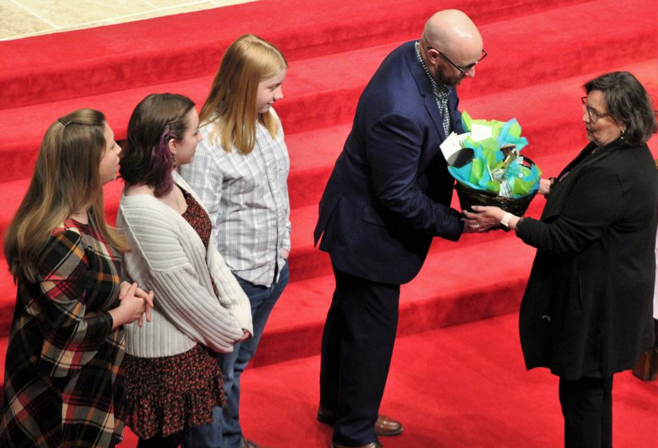 Karen Dansby, right, presents a gift basket to Brandon Hudson before he preaches for the first time Feb. 4 at First Baptist Church. The new senior pastor's family is to his right - wife Jill (from left), daughter Sophia and son Quinn.