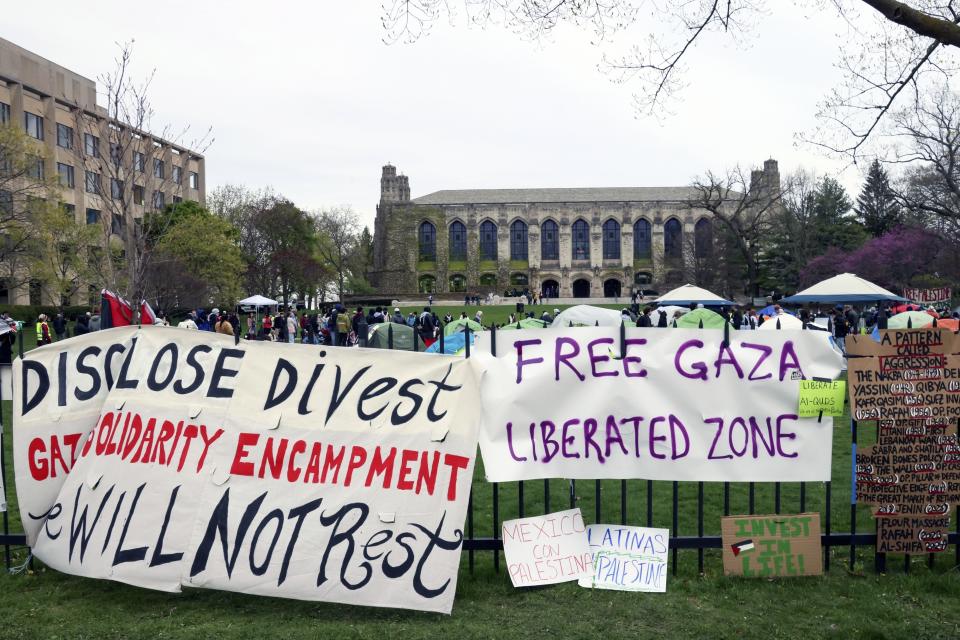 FILE - Signs are displayed outside a tent encampment at Northwestern University on Friday, April 26, 2024, in Evanston, Illinois. Leaders from Northwestern University, the University of California, Los Angeles, and Rutgers University are expected to testify before Congress on Thursday, the latest in a series of hearings spearheaded by House Republicans into how colleges have responded to pro-Palestinian protests on their campuses. (AP Photo/Teresa Crawford, file)