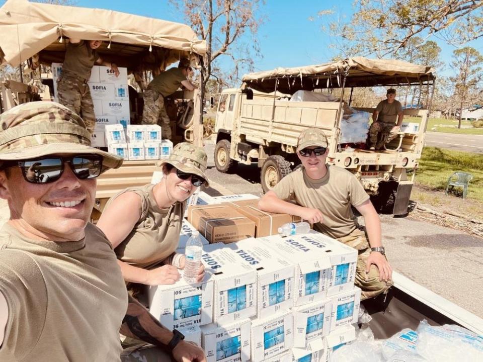 Oklahoma Air National Guard Staff Sgt. Macey Winegarner (center) helps distribute water to residents affected by Hurricane Ida in Louisiana