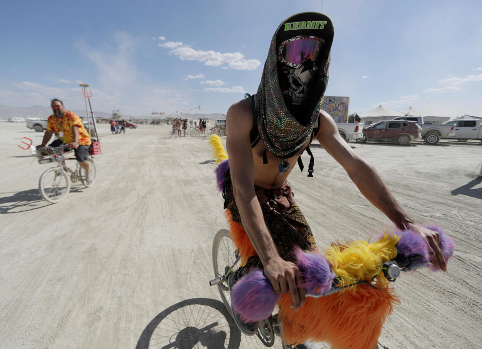 <p>Burning Man participant Bob Rafie of France pedals his bike through Black Rock City as approximately 70,000 people from all over the world gathered for the 1st full days of the annual Burning Man arts and music festival in the Black Rock Desert of Nevada, Aug. 28, 2017. (Photo: Jim Bourg/Reuters) </p>