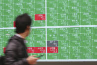 A man looks at an electronic stock board of a securities firm in Tokyo, Monday, Jan. 27, 2020. Shares tumbled Monday in the few Asian markets open as China announced sharp increases in the number of people affected in an outbreak of a potentially deadly virus. (AP Photo/Koji Sasahara)